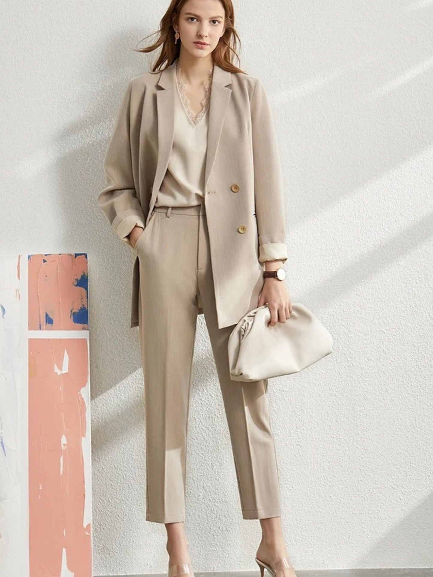 Damen-Hosenanzug in Beige, Modell stehend mit Handtasche.