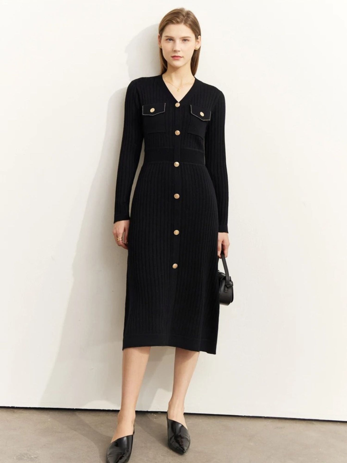 Schwarzes Strickkleid, Modell frontal mit Clutch.