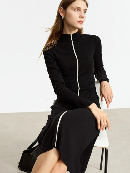 Schwarzes Strickkleid mit Reißverschluss, Modell sitzend.