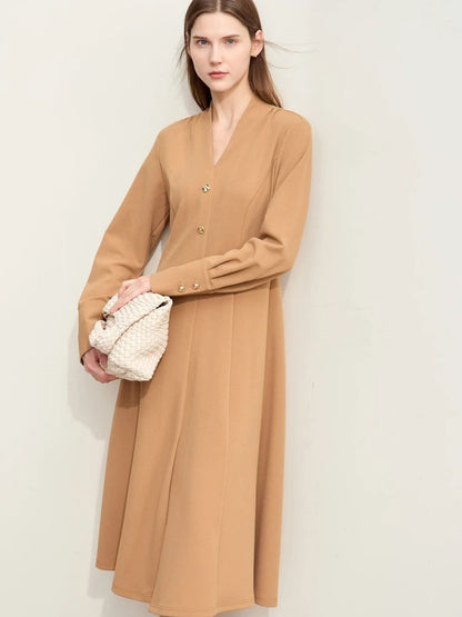 Beiges Midikleid mit V-Ausschnitt, Modell frontal mit Tasche.