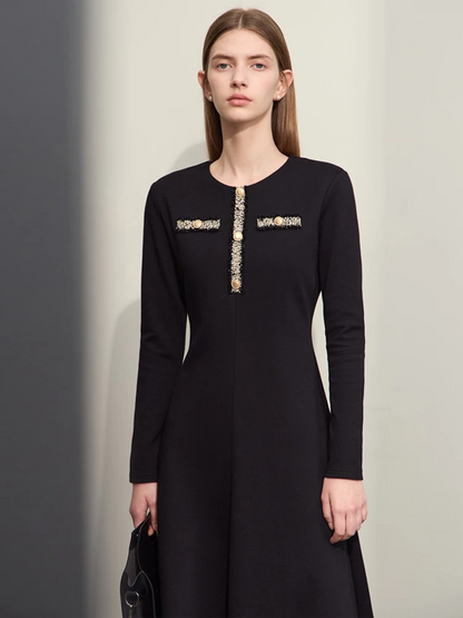 An elegant woman wearing a military inspired dress. The dress has long, fitted sleeves and an a-line silhouette. The bodice showcases a gold embroidery design with buttons. 