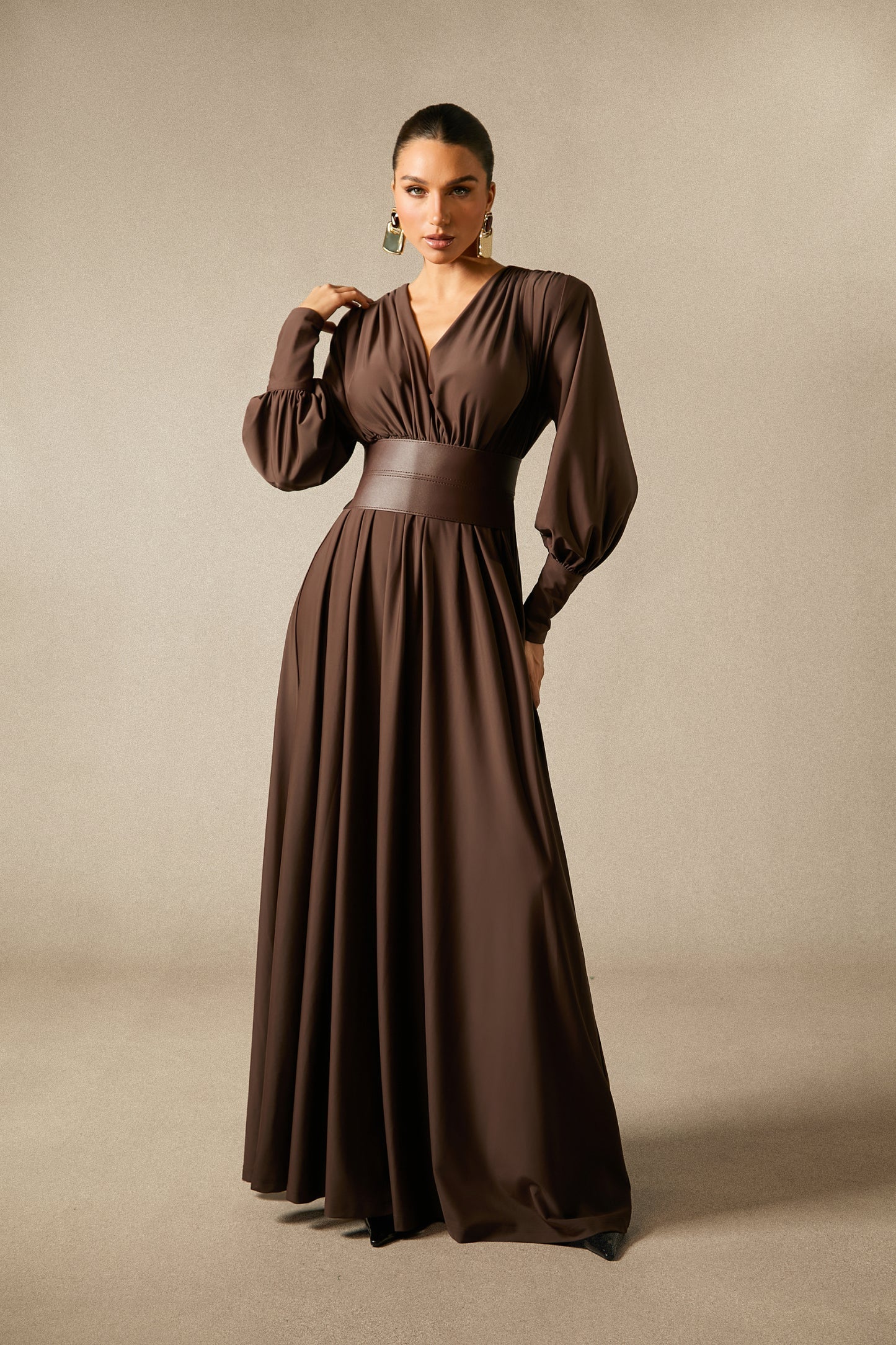 Modell in langem braunen Kleid mit Taillenband