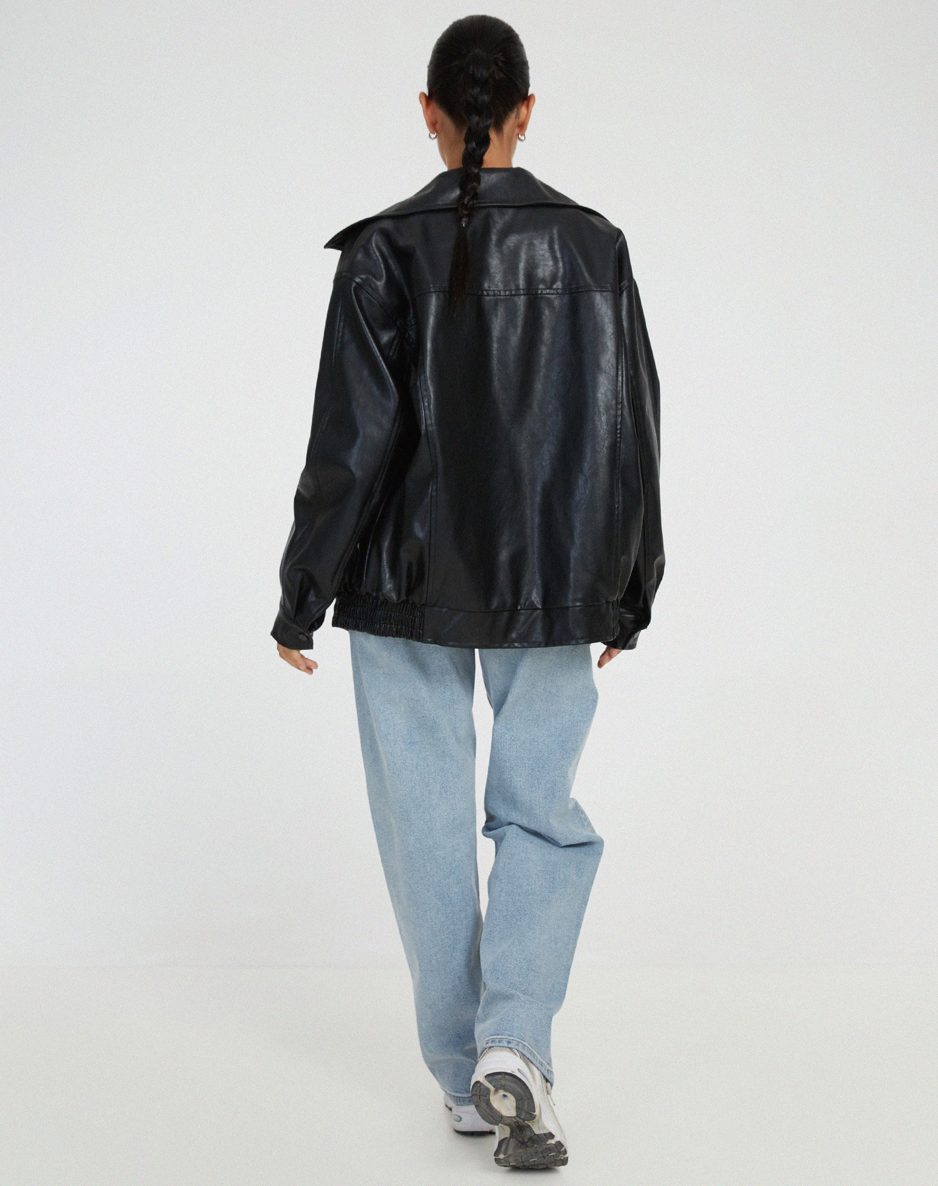 schwarze oversized Lederjacke mit elastischem Bund, kombiniert mit weitem Jeansschnitt