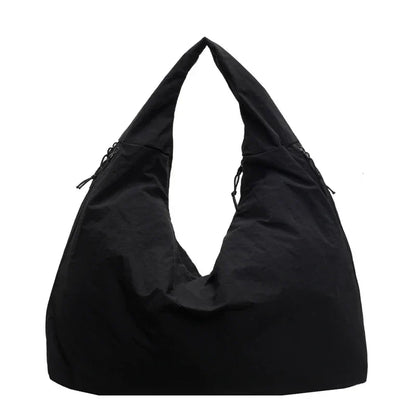 Schwarze Aether Tote Schultertasche auf Stuhl