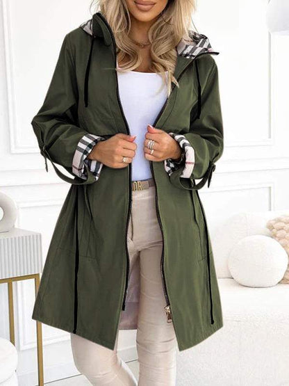 Dunkelgrauer Damen-Trenchcoat mit Kapuze und Karodetail, getragen von Frau.