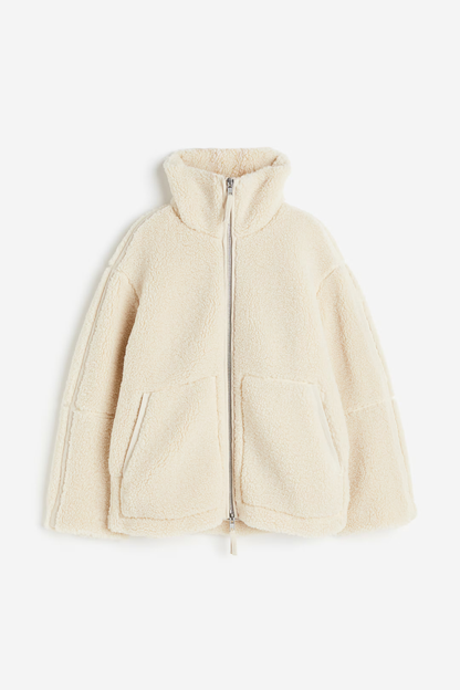 Cremefarbene Teddy-Fleece Jacke flach liegend
